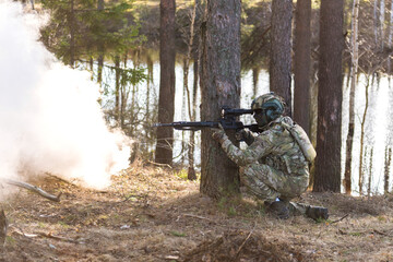 Fototapeta premium Soldiers in the forest. Military men in camouflage with weapons.