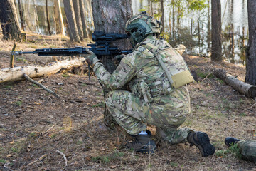 Soldiers in the forest. Military men in camouflage with weapons.