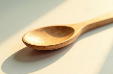 Wooden spoon placed on a light surface with gentle shadows