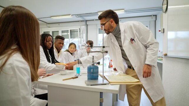 Science teacher instructing students in chemistry lab experiment