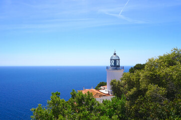 Far de Sant Sebastia lighthouse near Llafranc, in front of the blue sky and the Mediterranean Sea,...
