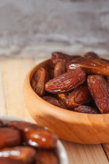 Dates Fruit in a wooden Bowl on a Wooden Table..