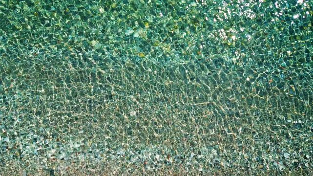 Top-down view of sea azure waves pattern and crystal clear water. Rhodes, Greece