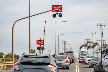 A line of cars and trucks passing a railroad level crossing at Mount Atkinson VIC Australia. 