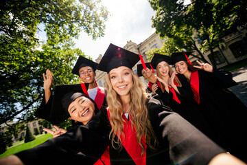 Portrait of group students make selfie show v-sign mortarboard gown graduation university building...