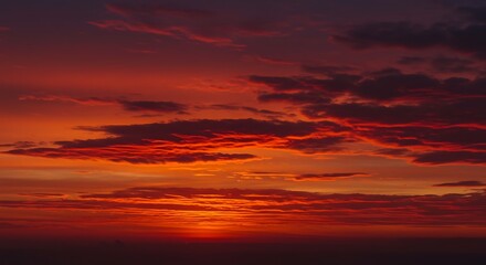 Fototapeta premium Fiery Sunset over Horizon: A breathtaking view of a vibrant sunset, painting the sky with fiery hues of red and orange, creating a dramatic and awe-inspiring spectacle.