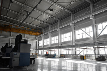 Fototapeta premium Yellow overhead traveling gantry crane beam on the pillars and truss ceilings of industrial building. Crane runway girder and metal structures. Interior of industrial storehouse or hangar