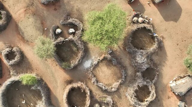 Aerial view of traditional samburu manyatta village with circular huts and thatched roofs surrounded by trees and bushland, Wamba, Samburu, Kenya.