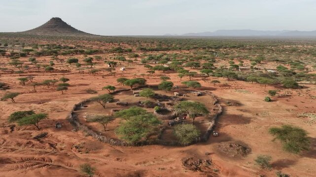 Aerial view of traditional Samburu Manyatta village surrounded by arid savanna and mountains, Wamba, Samburu, Kenya.