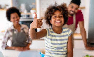 Obraz premium Overjoyed young african american family with kid have fun cooking at home together,