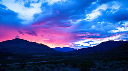 Obraz premium Vibrant sunset over mountains with dramatic clouds and colorful sky