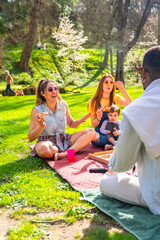 Fototapeta premium Happy family enjoying pizza at sunny park picnic