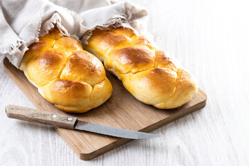 Traditional Easter braided bread. Tsoureki braid on white wooden table. Copy space