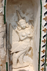 Intricate stone carving of a kinnari, a mythical half-bird, half-woman creature, at Wat Arun temple in Bangkok, Thailand