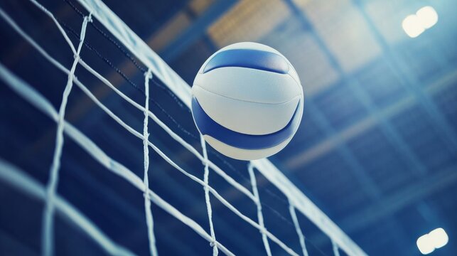 Low-angle close-up of a white leather volleyball soaring over the net in an indoor volleyball arena during a competitive match, capturing the fast-paced action and intensity of the game.


