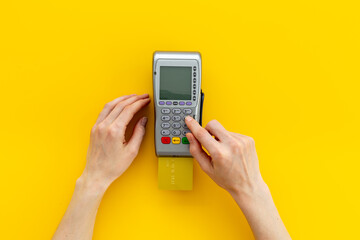 Paying a bill at a cafe - female hands with wireless bank payment terminal and credit card