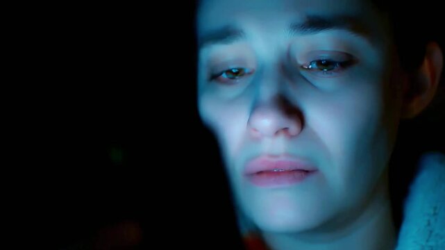 4K cinematic close-up of a sad woman staring at her phone at night, illuminated by blue screen light, emotional depth, loneliness, heartbreak, isolation, sorrowful expression