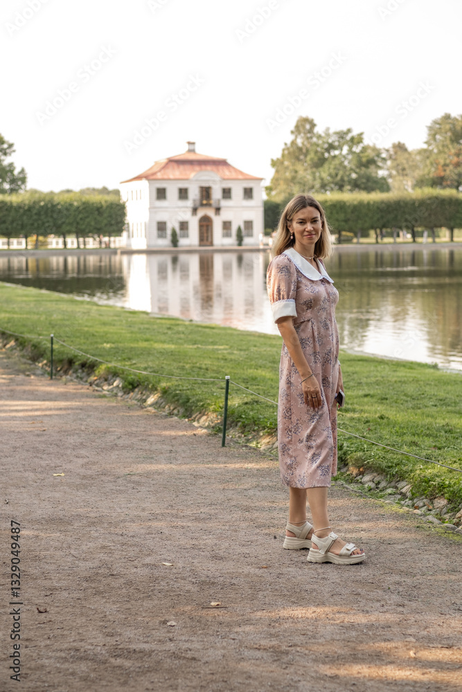 Aufkleber Walking beside the tranquil waters of Peterhof Gardens with historic architecture in the background during a sunny afternoon