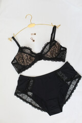 Woman's silk erotic lingerie on the white bed sheets. Valentine's day concept. Lace sexy female underwear. Beauty, fashion blogger concept. Female bra, panties, erotic clothes. Lingerie advertising