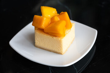 mango cheese cake with fresh mango on white plate