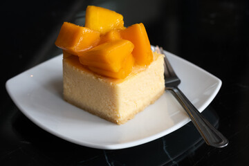 mango cheese cake with fresh mango on white plate