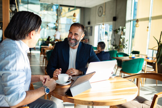 Diverse business team collaborating in modern cafe
