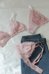 Woman's silk erotic lingerie on the white bed sheets. Valentine's day concept. Lace sexy female underwear. Beauty, fashion blogger concept. Female bra, panties, erotic clothes. Lingerie advertising
