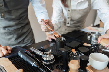 Coffee Brewing and Barista Techniques. Two baristas skillfully preparing coffee using specialty tools and techniques.