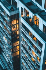 Fototapeta premium A building with lots of windows glowing from within against a night sky.