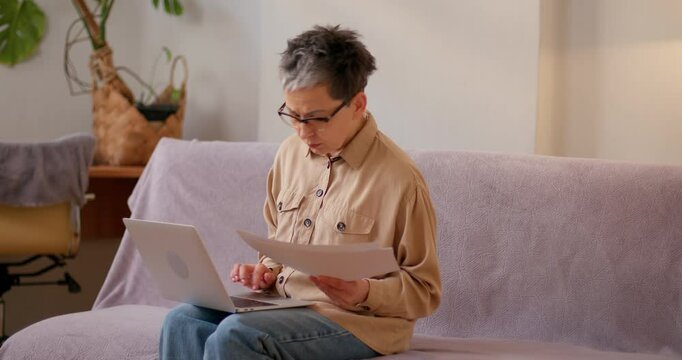 Latin woman reviews statistical data while sitting with laptop