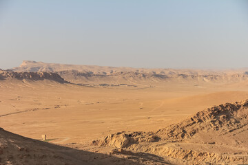 Expansive Arid Desert Landscape With Mountainous Horizon Under Clear Blue Sky