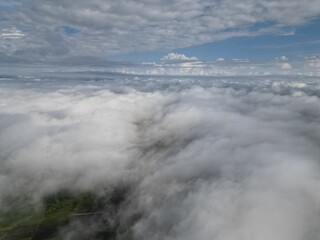 Aerial view of a landscape covered by clouds during the day