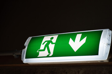 Emergency exit sign on a dark background.