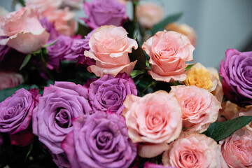Purple and pink roses in a large bouquet.