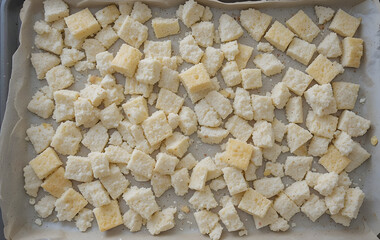 Layer of homemade croutons on a baking sheet lined with a parchment paper