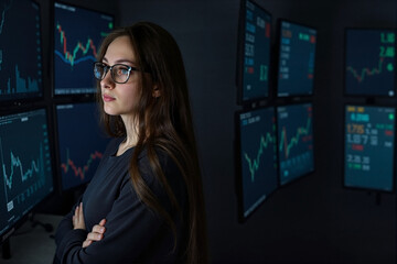 Thoughtful Female Analyst, Arms Crossed, Studying Financial Charts on Monitors in the Dark, Concept of Investment and Market Analytics, Digital Technology.