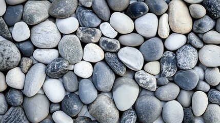 A textured background of smooth, gray and white pebbles in various shapes and sizes, ideal for natural themes or landscaping projects.