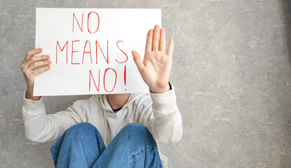 Portrait of a young confident woman holding a banner saying "no means no", symbolizing empowerment, women's rights and protection. Awareness of gender-based violence