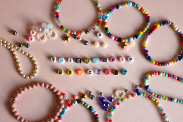 Friendship bracelet spelled with letter beads. Colorful handmade bracelets and various beads. Flat...