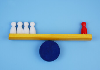 Four white and one red wooden people figures balancing on scales. Skills and talents concept.
