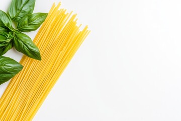 Uncooked yellow spaghetti pasta with fresh basil leaves and cherry tomatoes on white background top view Italian cuisine and organic food concept