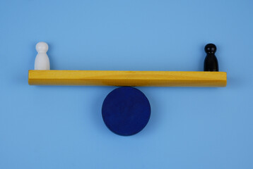 White and black figure of people balance on scales. Equality of races concept.	