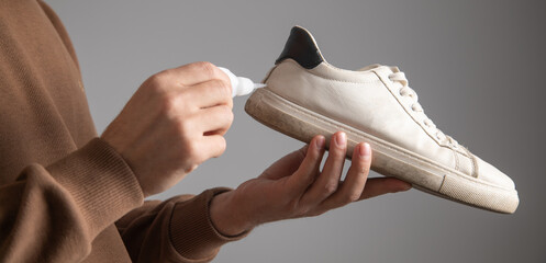 Caucasian man glues shoe. Repairing