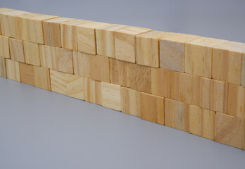 Wooden cubes wall on gray background. 