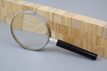 Wooden wall under magnifying glass. Check security and protection concept.