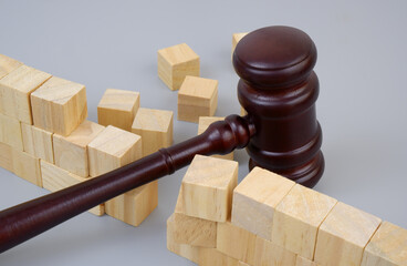 Judge gavel and broken wall on gray background.	