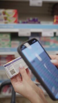 A customer scans the QR code on a toothpaste package to access product details while standing in a store aisle filled with various dental care items.