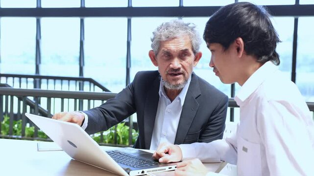 Asian senior professor is giving advice  to the college student on the research thesis while sitting in the university faculty for education, academic and business concept