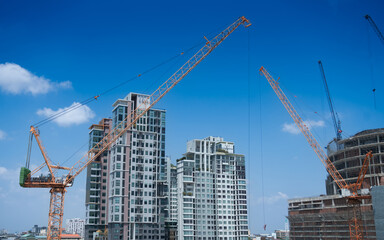 Urban construction site with tower cranes and modern high-rise buildings under development. City growth, real estate investment, and infrastructure expansion concept