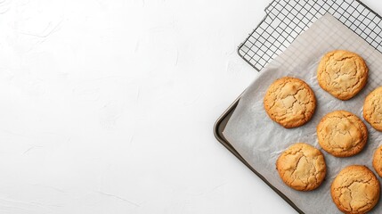 Topdown view of a baking sheet with freshly baked cookies, placed alongside a cooling rack, white minimalist kitchen scene